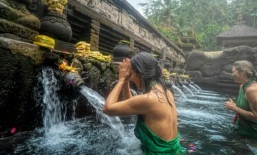 Women participating in a sacred water purification ritual at Pura Tirta Empul Temple in Bali, Indonesia.