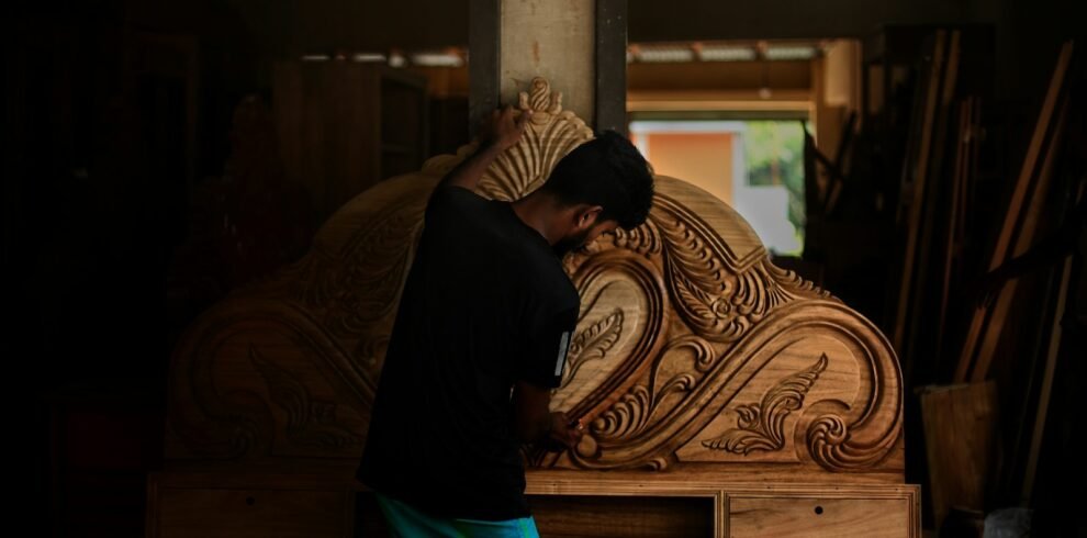 A man standing next to a large wooden object