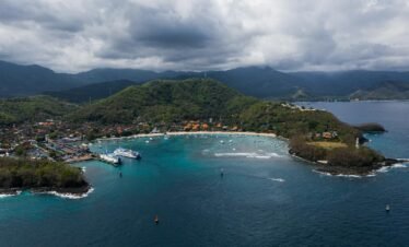 A breathtaking aerial view of a vibrant coastal landscape with turquoise waters and lush greenery.