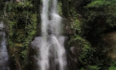 A man standing in front of a waterfall
