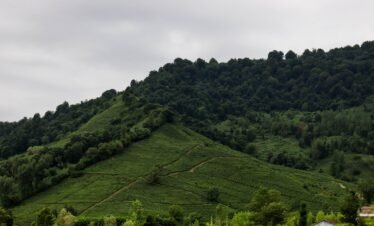A lush, green mountain beneath a cloudy sky.
