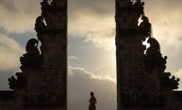 woman wearing beige dress in the middle of arch temple