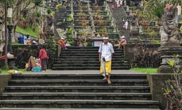 a man walking up some steps in front of a building