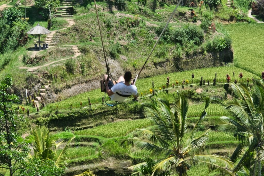 woman in white shirt sitting on green grass field during daytime