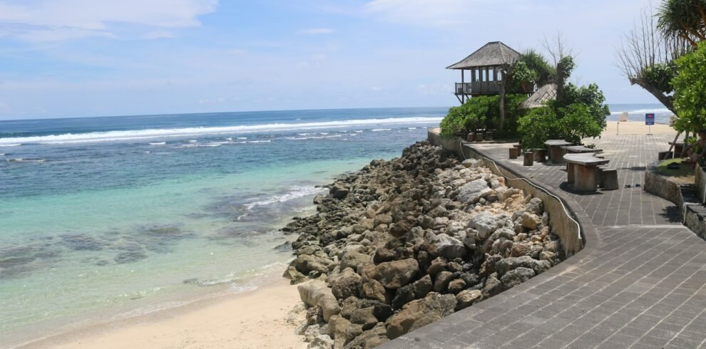a walkway leading to a beach with a gazebo in the distance