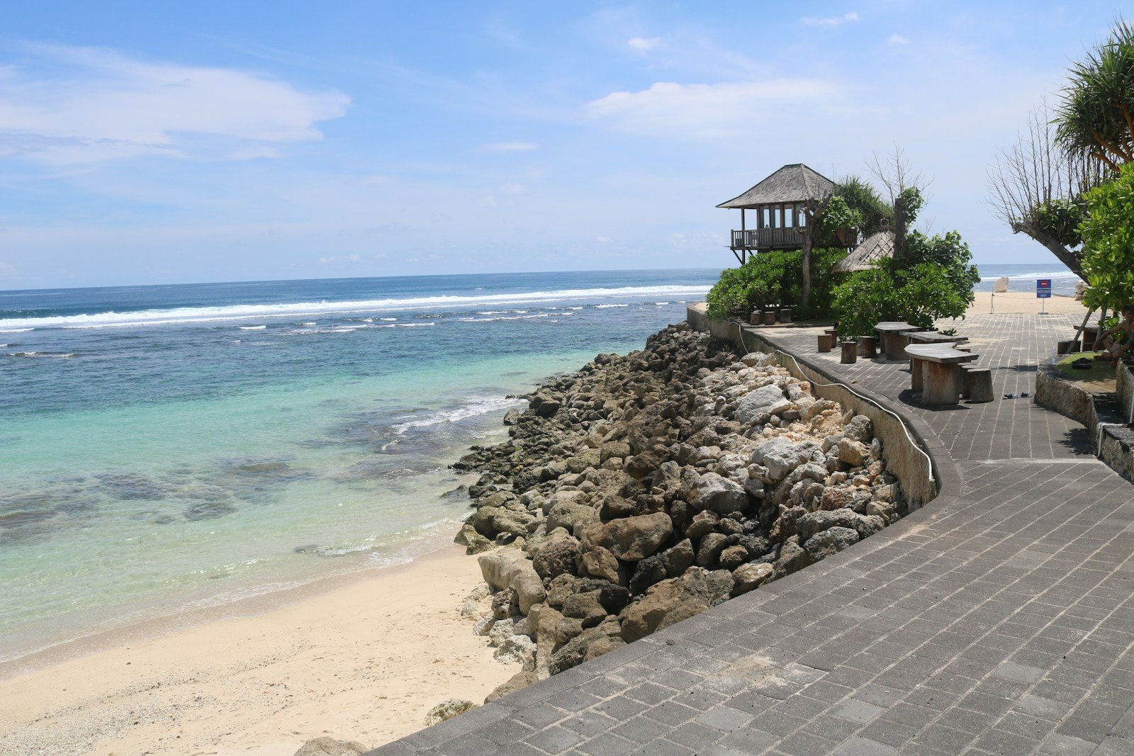 a walkway leading to a beach with a gazebo in the distance